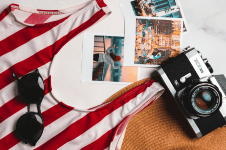 A red and white striped swimsuit, sunglasses, and a camera, symbolizing finding your niche in leisure activities